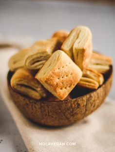 a wooden bowl filled with crackers on top of a table