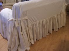 a white bed with ruffled bedspread on it