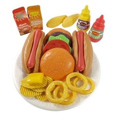 a plastic plate with hot dogs, hamburgers and fries on it next to condiments