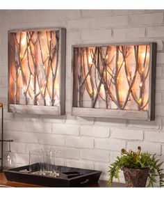 two metal wall art pieces hanging on a brick wall