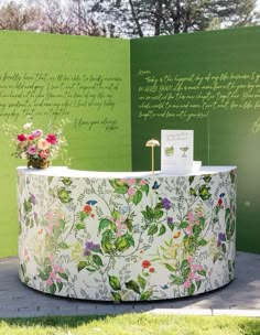 a flower covered counter in front of a green wall with writing on the walls behind it