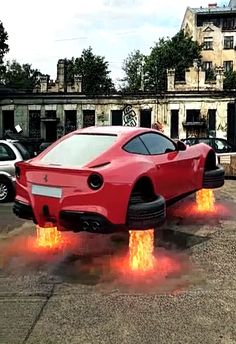 a red sports car with flames coming out of it's rear end in a parking lot