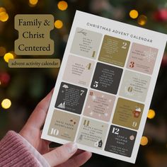 a person holding up a christmas and christ centered activity calendar