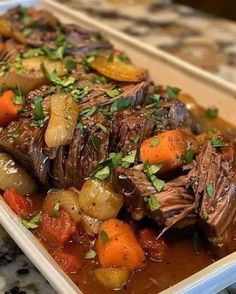 a white plate topped with meat and vegetables on top of a kitchen counter covered in gravy