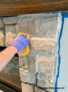 a person in blue gloves cleaning a brick fireplace