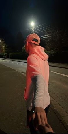 a man riding a skateboard down a street at night