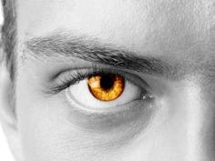 a man's eye with an orange iris