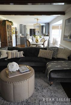 a living room filled with furniture and a large ottoman in front of a fire place