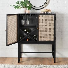 a black cabinet with wine bottles in it next to a white brick wall and rug