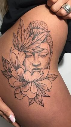 a woman's stomach with a tattoo on it and flowers around the butts