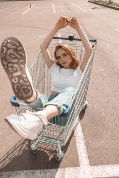 a woman sitting in a shopping cart with her feet up