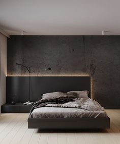 a large bed sitting in the middle of a bedroom next to a wall mounted lamp