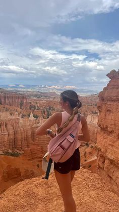 a woman standing on top of a cliff