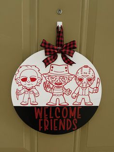 a welcome sign hanging on the front door of a house with cartoon characters painted on it