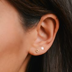 a woman's ear is shown with two small stars on the side of her ear