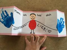 a child's hand is holding up a book