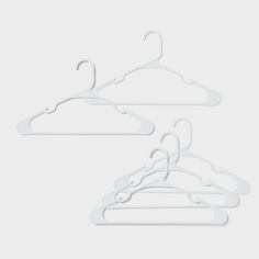 three white clothes hangers on a gray background