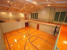 an indoor basketball court with hard wood flooring and railings on the side wall