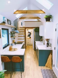 the interior of a tiny home with wood flooring and white walls, along with wooden stairs