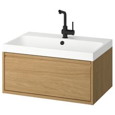 a bathroom sink with a black faucet and wooden cabinet