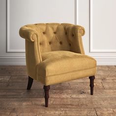 a yellow chair sitting on top of a hard wood floor next to a white wall