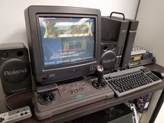 a computer monitor sitting on top of a desk next to a keyboard and sound equipment