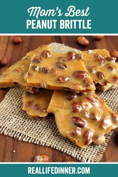 three pieces of peanut brittle on top of a wooden table with peanuts around it and the words, mom's best peanut brittle