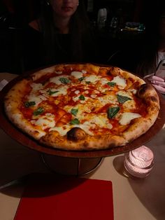 a large pizza sitting on top of a wooden pan