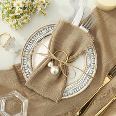 a place setting with napkins, silverware and flowers