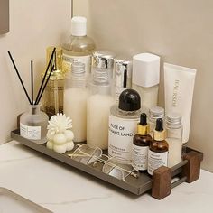 an assortment of beauty products are displayed on a bathroom countertop in front of a mirror