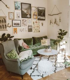 a living room with green couches and pictures on the wall above them, along with other furniture