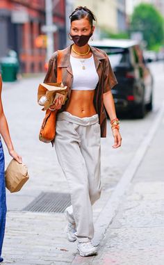 a woman walking down the street wearing a face mask