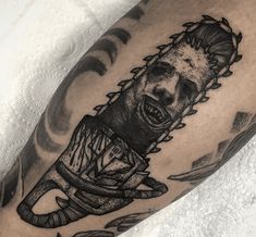 a man's arm with a black and white tattoo on it, depicting an evil clown