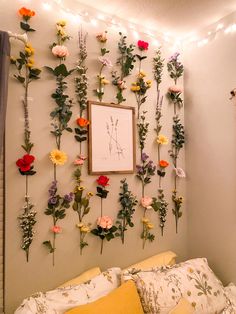 a bedroom with flowers on the wall and lights hanging above it's headboard