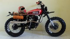 a red dirt bike parked next to a wall