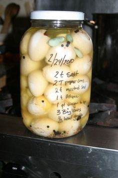 a glass jar filled with lots of yellow and white eggs sitting on top of a stove