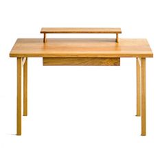 a wooden desk with two legs and a small shelf on the top that holds a laptop