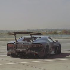 a black sports car is parked on the tarmac with its hood open and it's top down