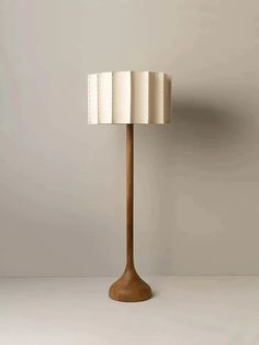 a lamp that is sitting on top of a table next to a white wall and floor