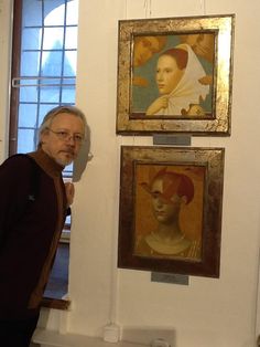 a man standing in front of some paintings