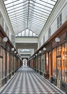 the inside of a large building with lots of windows on each side and a checkered floor