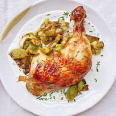 a white plate topped with chicken, potatoes and brussel sprouts on top of a table