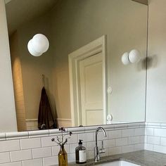 a bathroom sink sitting under a large mirror