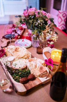 a table topped with lots of food and wine