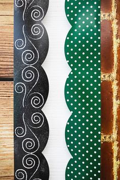 two green and white decorative paper strips on wood planks with polka dot designs in the center