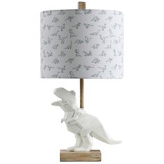 a white dinosaur lamp on a wooden base