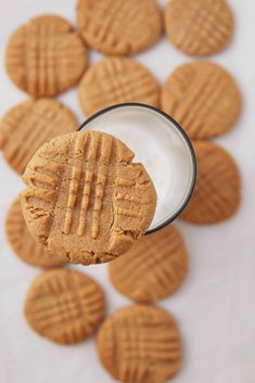 peanut butter cookies with a glass of milk in front of them on a white surface