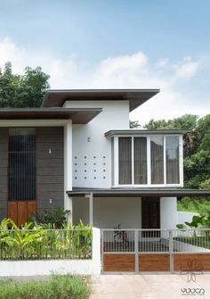 a white and brown house with trees in the background