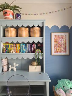 a book shelf with books and toys on it in a child's playroom