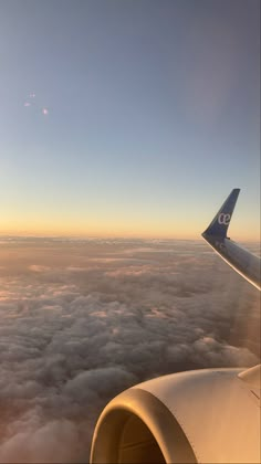 the wing of an airplane as it flies over clouds